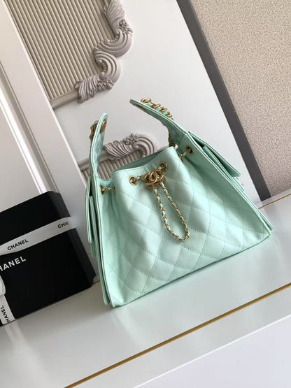 Mint green handbag with gold chain on a white surface, with Chanel branding in the background.