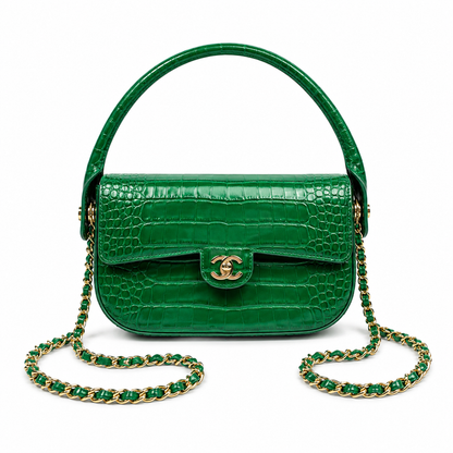 A green crocodile-embossed leather handbag with a top handle, gold-tone interlocking CC clasp, and a green-and-gold chain strap, shown on a plain white background.