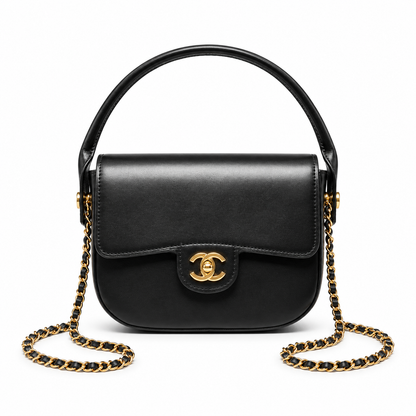 A black leather Chanel handbag with a top handle, gold-tone CC turn-lock clasp, and a black-and-gold chain strap, shown on a plain white background.