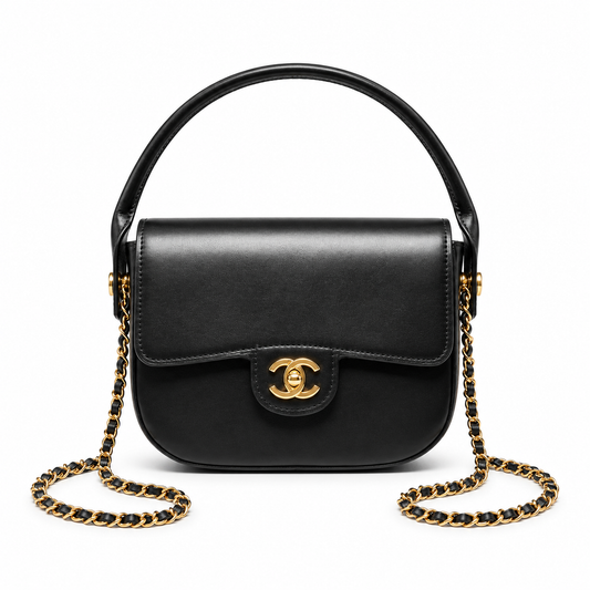 A black leather Chanel handbag with a top handle, gold-tone CC turn-lock clasp, and a black-and-gold chain strap, shown on a plain white background.